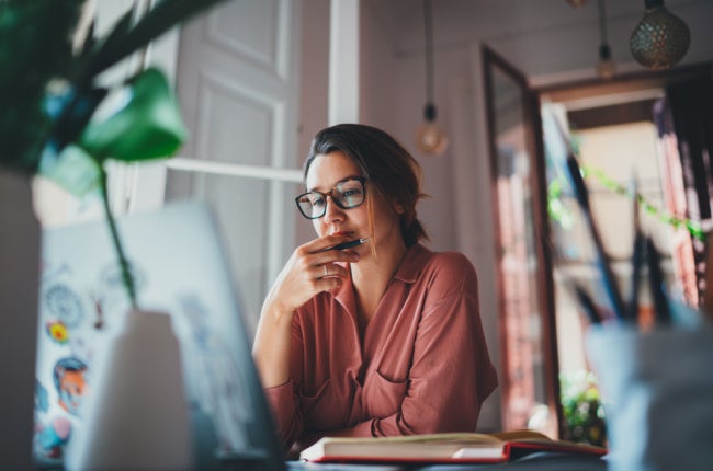 woman thinking in front of laptop