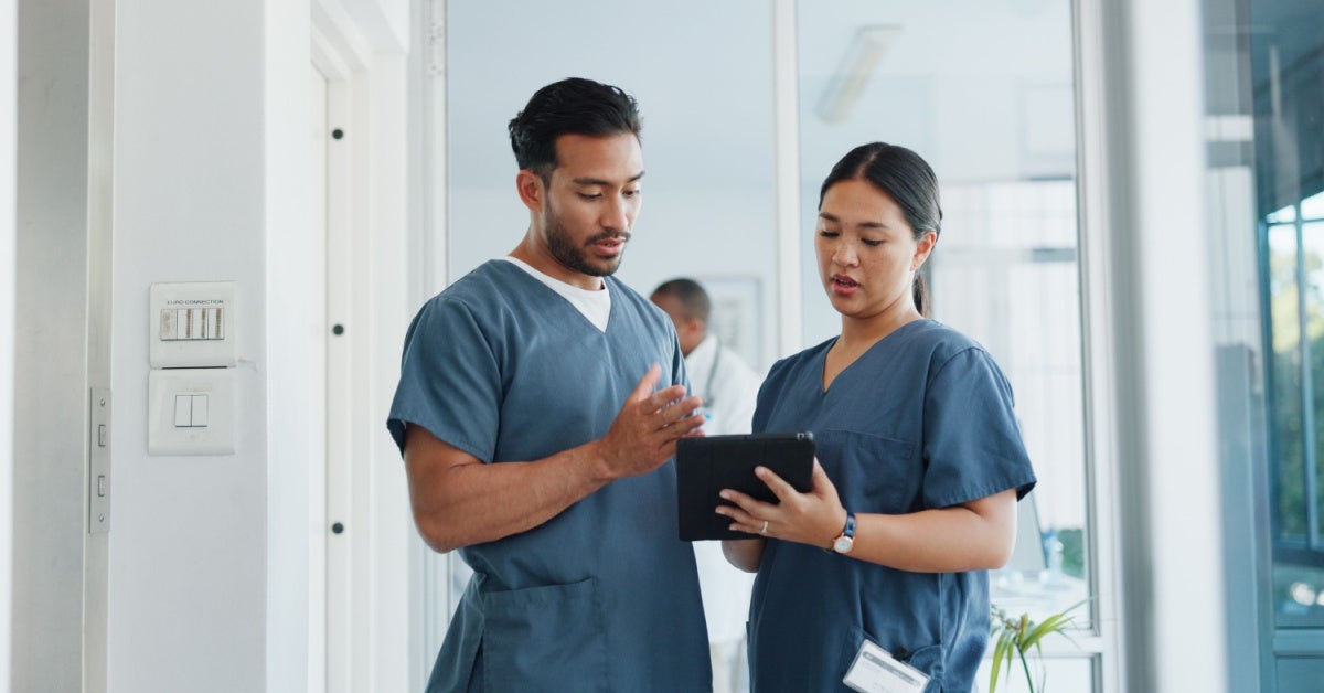 two nurse leaders talking with a clipboard