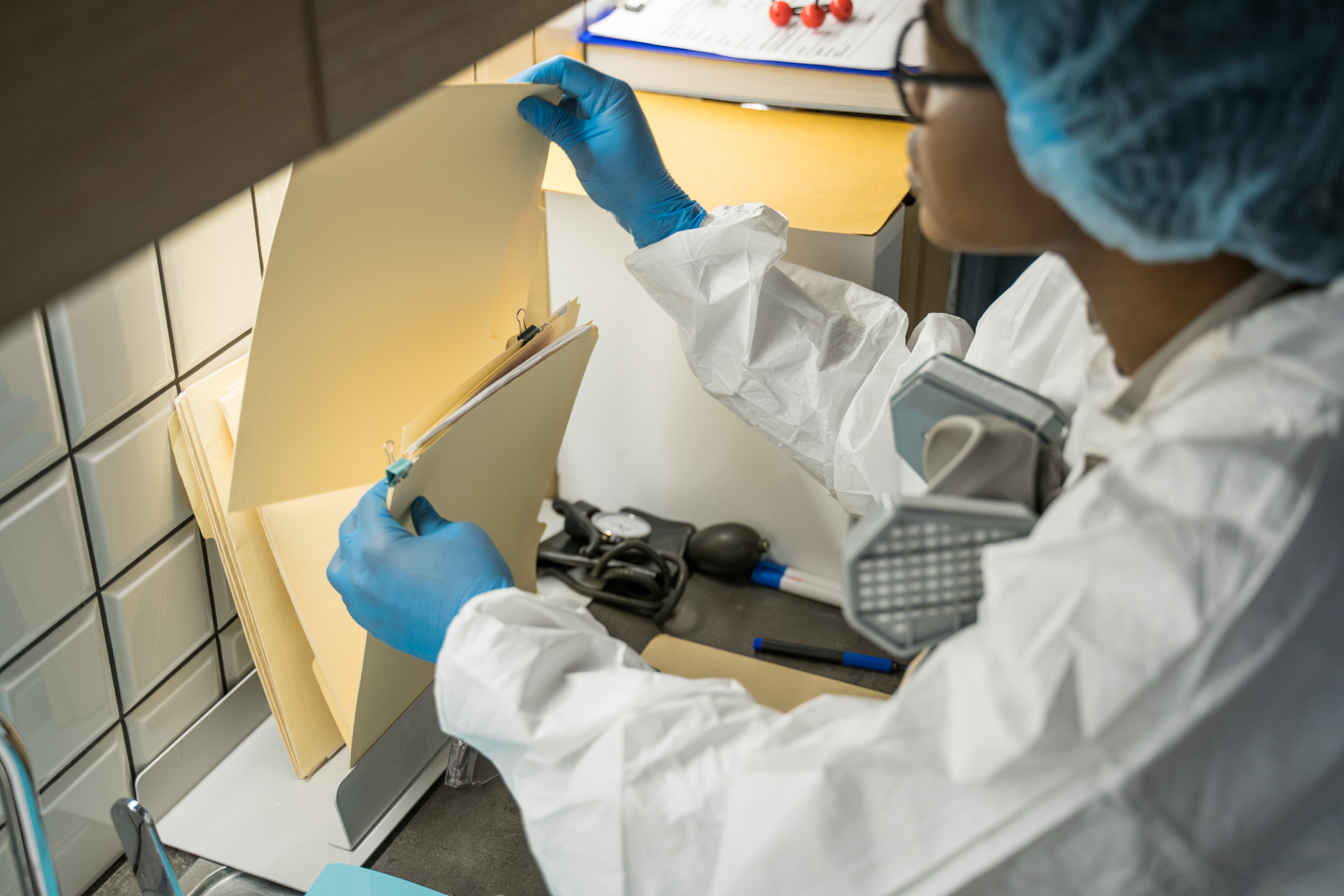 a forensic nurse with glasses checking files
