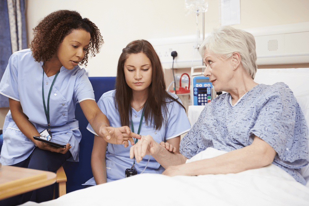 trainee nurse with a patient and educator